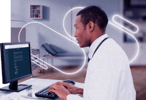 healthcare professional sitting at desk working on computer 